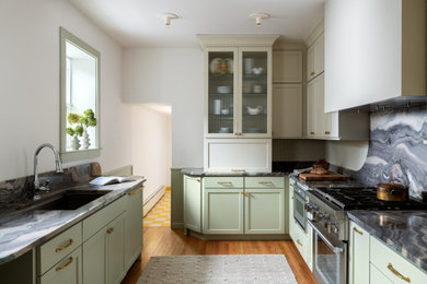 Inspiration for a mid-sized transitional galley medium tone wood floor enclosed kitchen remodel in Philadelphia with shaker cabinets, quartzite countertops, stainless steel appliances, an undermount sink, green cabinets, green backsplash, wood backsplash, no island and gray countertops