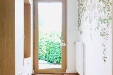 Idées déco pour un petit hall d'entrée classique avec un mur blanc, tomettes au sol, une porte simple, une porte en bois clair, un sol rouge et du papier peint.