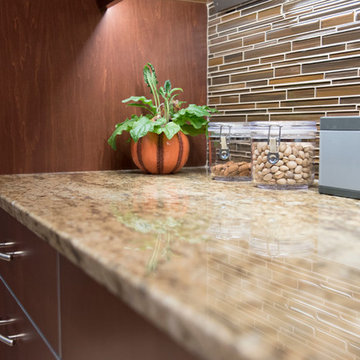 Glass backsplash tile is highlighted by the under-cabinet lighting