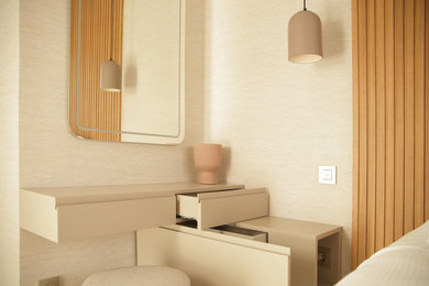 Imagen de dormitorio principal y gris y negro minimalista de tamaño medio con paredes beige, suelo de madera clara, suelo gris y papel pintado
