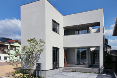 Inspiration pour une façade de maison grise nordique de taille moyenne et à un étage avec un toit en appentis, un toit en métal et un toit gris.