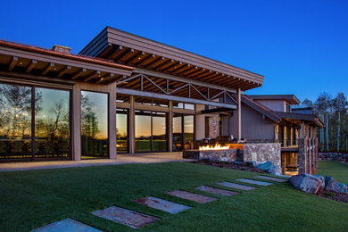 Design ideas for a large modern drought-tolerant backyard stone landscaping in Salt Lake City with a fireplace.