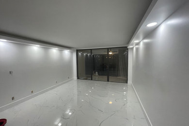 Imagen de salón para visitas abierto moderno grande sin televisor con paredes blancas, suelo de baldosas de cerámica y suelo blanco