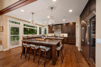 Kitchen - traditional u-shaped dark wood floor and brown floor kitchen idea in Seattle with shaker cabinets, dark wood cabinets, gray backsplash, glass tile backsplash, stainless steel appliances, two islands and gray countertops