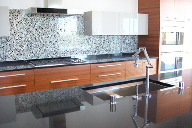 Open concept kitchen - contemporary open concept kitchen idea in Albuquerque with an undermount sink, flat-panel cabinets, medium tone wood cabinets, granite countertops, blue backsplash, mosaic tile backsplash and an island