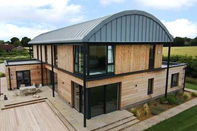 Inspiration for a large contemporary two floor detached house in Kent with wood cladding.