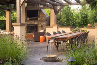 Mid-sized arts and crafts backyard patio in Other with a fire feature, stamped concrete and a pergola.