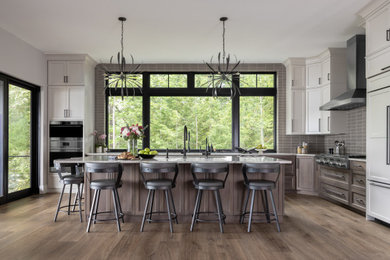 Example of a large transitional l-shaped laminate floor and brown floor eat-in kitchen design in Boston with shaker cabinets, medium tone wood cabinets, quartzite countertops, gray backsplash, porcelain backsplash, stainless steel appliances, an island and white countertops