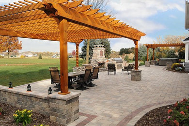 Design ideas for a large backyard patio in Milwaukee with brick pavers.
