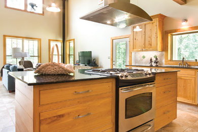 Elegant open concept kitchen photo in New Orleans with shaker cabinets and medium tone wood cabinets