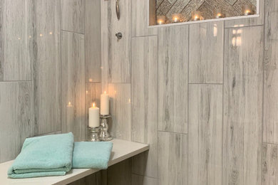 Mid-sized transitional master porcelain tile laminate floor, brown floor and double-sink bathroom photo in Other with furniture-like cabinets, beige cabinets, a one-piece toilet, an integrated sink, marble countertops, multicolored countertops, a niche and a freestanding vanity