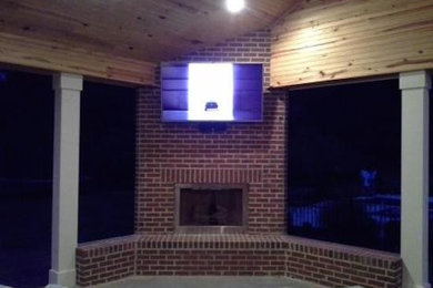 Inspiration for a small transitional enclosed concrete floor living room remodel in Charleston with a standard fireplace, a brick fireplace and a wall-mounted tv