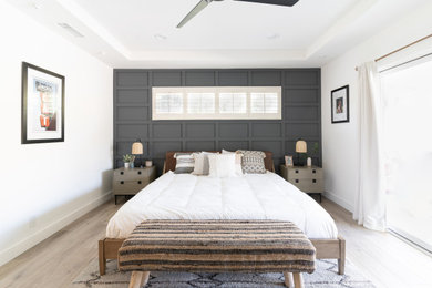 Ejemplo de dormitorio principal tradicional renovado grande sin chimenea con suelo vinílico, suelo marrón, bandeja y boiserie