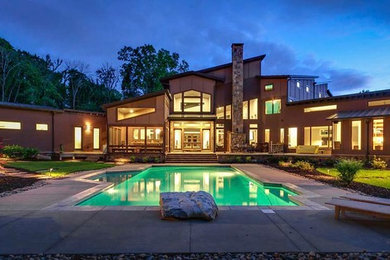 Inspiration for a large contemporary backyard concrete paver and custom-shaped lap pool remodel in Other