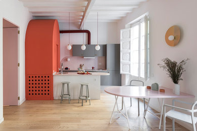 This is an example of a contemporary u-shaped eat-in kitchen in Barcelona with flat-panel cabinets, grey cabinets, light hardwood floors, a peninsula and beige floor.