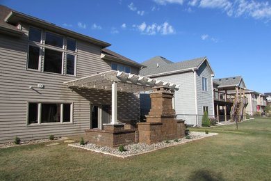 Inspiration for a mid-sized timeless backyard concrete patio remodel in Other with a fire pit and a pergola
