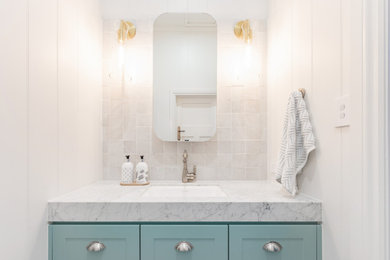 This is an example of a small contemporary bathroom in Brisbane with blue cabinets, white tiles, mosaic tiles, marble worktops, white worktops and a single sink.