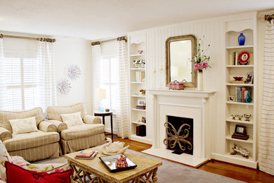 Photo of a traditional living room in Dallas with white walls, medium hardwood floors and a standard fireplace.