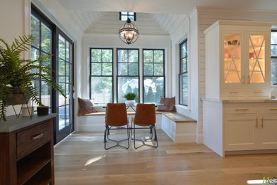 Enclosed kitchen - large transitional l-shaped enclosed kitchen idea in Boston with flat-panel cabinets, white cabinets, quartz countertops, white backsplash, quartz backsplash, white appliances, an island and white countertops