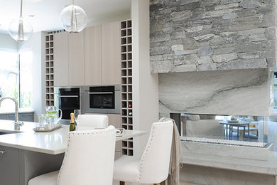Trendy l-shaped light wood floor eat-in kitchen photo in Vancouver with flat-panel cabinets, gray cabinets, quartz countertops and an island