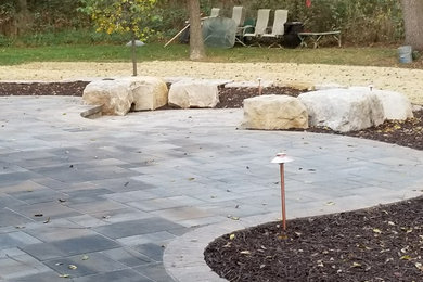 Inspiration for a mid-sized traditional partial sun backyard concrete paver landscaping in Milwaukee.