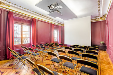 Imagen de cine en casa cerrado clásico renovado grande con paredes púrpuras, suelo de madera clara, pantalla de proyección y suelo marrón