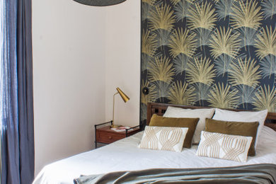 Imagen de dormitorio principal actual de tamaño medio con paredes beige, suelo de madera oscura y papel pintado