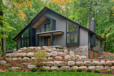 Diseño de fachada de casa gris y negra escandinava extra grande de dos plantas con revestimientos combinados, tejado a dos aguas y tejado de varios materiales