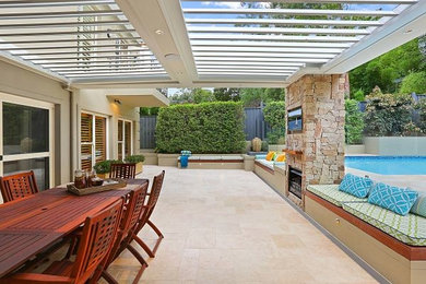 Inspiration for a contemporary backyard patio in Sydney with natural stone pavers and a pergola.