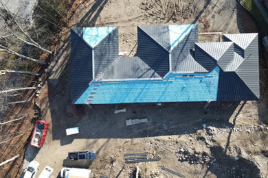 Minimalist house exterior photo in Toronto with a hip roof, a metal roof and a black roof