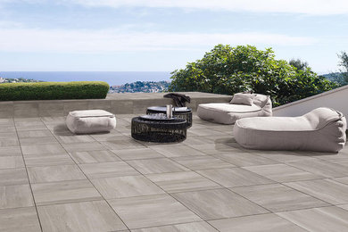 Example of a large minimalist backyard tile patio design in Miami with no cover