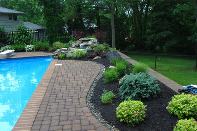 Photo of a mid-sized country backyard full sun garden for summer in New York with a water feature and concrete pavers.