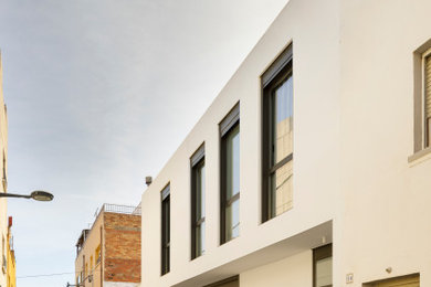 Foto de fachada de casa blanca contemporánea de tamaño medio de dos plantas con revestimiento de estuco y tejado plano
