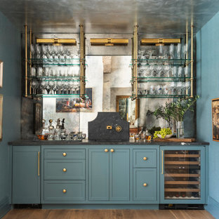 Diseño de bar en casa con fregadero clásico renovado con fregadero integrado, armarios con paneles empotrados, puertas de armario azules, encimera de mármol, salpicadero con efecto espejo y encimeras negras
