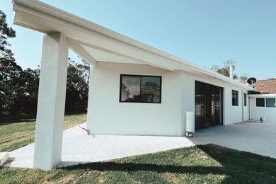 Diseño de fachada de casa blanca y gris campestre de tamaño medio de una planta con ladrillo pintado, tejado a dos aguas y tejado de metal