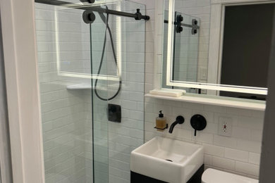 Example of a small transitional 3/4 white tile and ceramic tile ceramic tile, black floor, single-sink and shiplap wall bathroom design in San Luis Obispo with recessed-panel cabinets, black cabinets, a two-piece toilet, white walls, a vessel sink and a floating vanity