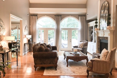 Inspiration for a large timeless formal medium tone wood floor living room remodel in Atlanta with beige walls, a standard fireplace and no tv