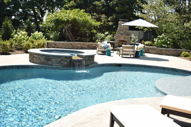 Large elegant backyard stamped concrete and kidney-shaped natural hot tub photo in Baltimore