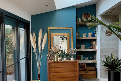 Aménagement d'un salon contemporain avec un mur bleu et un sol en bois brun.