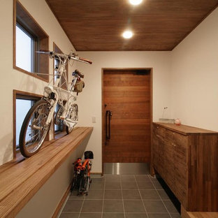 他の地域の片開きドアコンテンポラリースタイルのおしゃれな玄関 (白い壁、茶色いドア、グレーの床) の写真