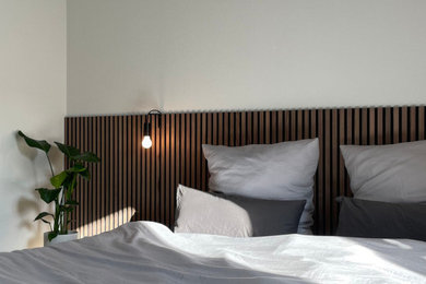 Mittelgroßes Modernes Hauptschlafzimmer mit grauer Wandfarbe, braunem Holzboden, braunem Boden und Holzwänden in München