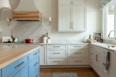 Kitchen - u-shaped brown floor kitchen idea in New Orleans with an island