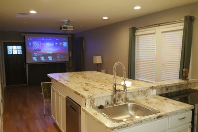 Inspiration for a transitional light wood floor kitchen remodel in Milwaukee with a drop-in sink, recessed-panel cabinets, white cabinets, soapstone countertops, stainless steel appliances and an island