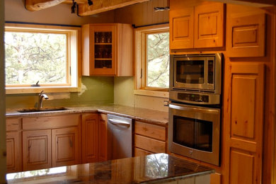 Photo of a large kitchen in Denver with a drop-in sink, recessed-panel cabinets, medium wood cabinets and granite benchtops.
