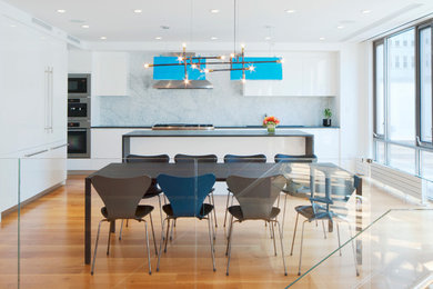 Photo of a contemporary galley open plan kitchen in New York with white splashback and stone slab splashback.