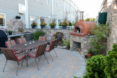 Inspiration for a mid-sized timeless backyard stone patio remodel in Baltimore with a fire pit and no cover