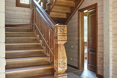 Imagen de escalera en U campestre de tamaño medio con escalones de madera, contrahuellas de madera, barandilla de madera y machihembrado
