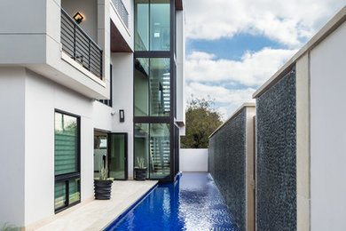 Inspiration for a mid-sized contemporary side yard tile and rectangular lap pool fountain remodel in Austin