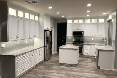 Inspiration for a timeless u-shaped kitchen remodel in Los Angeles with raised-panel cabinets, white cabinets and an island