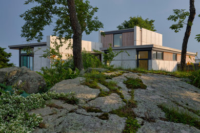 Modelo de fachada de casa gris retro pequeña de dos plantas con revestimiento de hormigón y tejado plano
